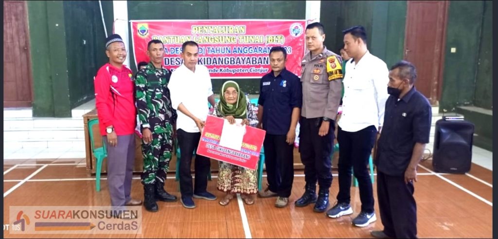 Foto : Simbolis Kepala Desa Cikidangbayabang sedang melaksanakan pembagian BLT DD tahun 2023 kepada seorang KPM.